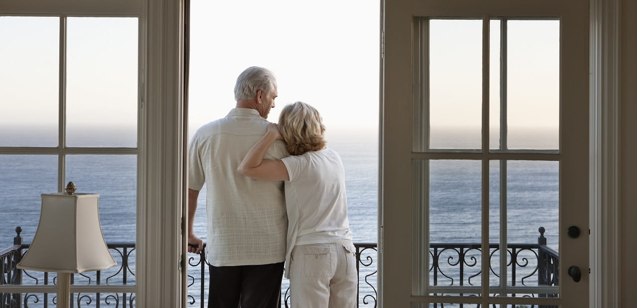 Couple looking at ocean view from balcony.