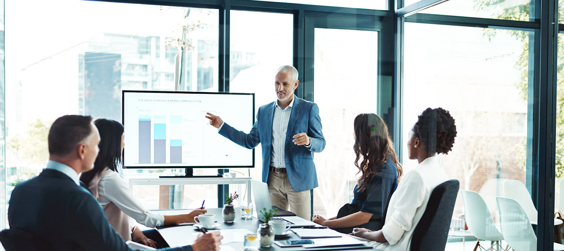 Businessman giving a presentation in a board room in front of his colleagues.