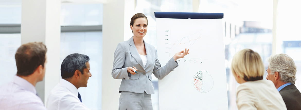 A woman giving a presentation to 4 people.