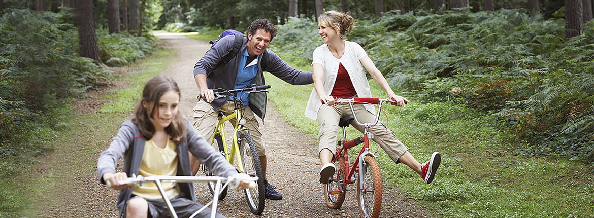 Three people riding bikes on a trail.