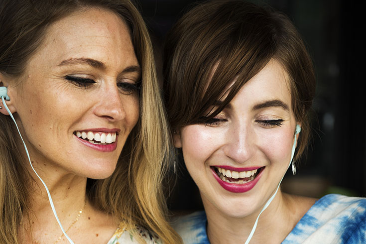 Women smiling and listening to headphones
