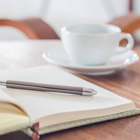 pen notes and a coffee cup on a table