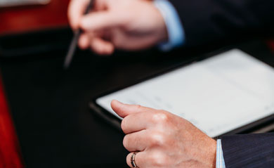 hands on desk holding a pen