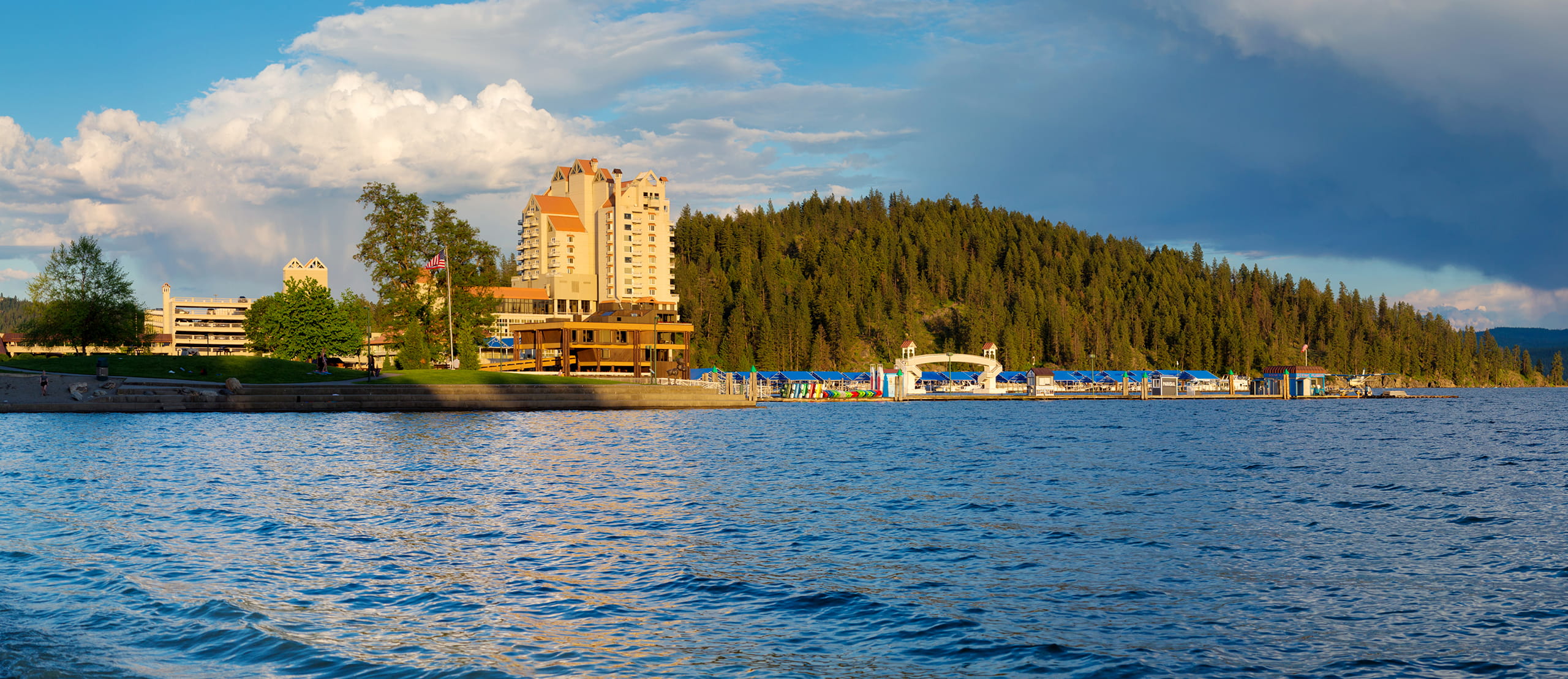 Panoramic view of Lake Coeur d'Alene shoreline with the Coeur d'Alene Resort visible, stormy spring evening skies