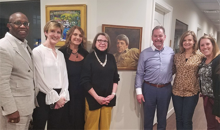 Group of people standing in front of a painting