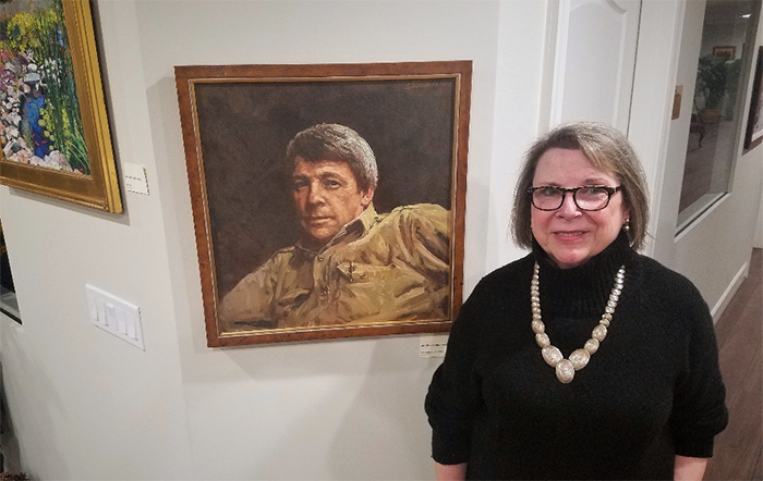 Woman standing next to a painting