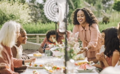 Happy family having food together while social gathering at backyard during party