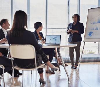 Woman presenting around a table of professionals